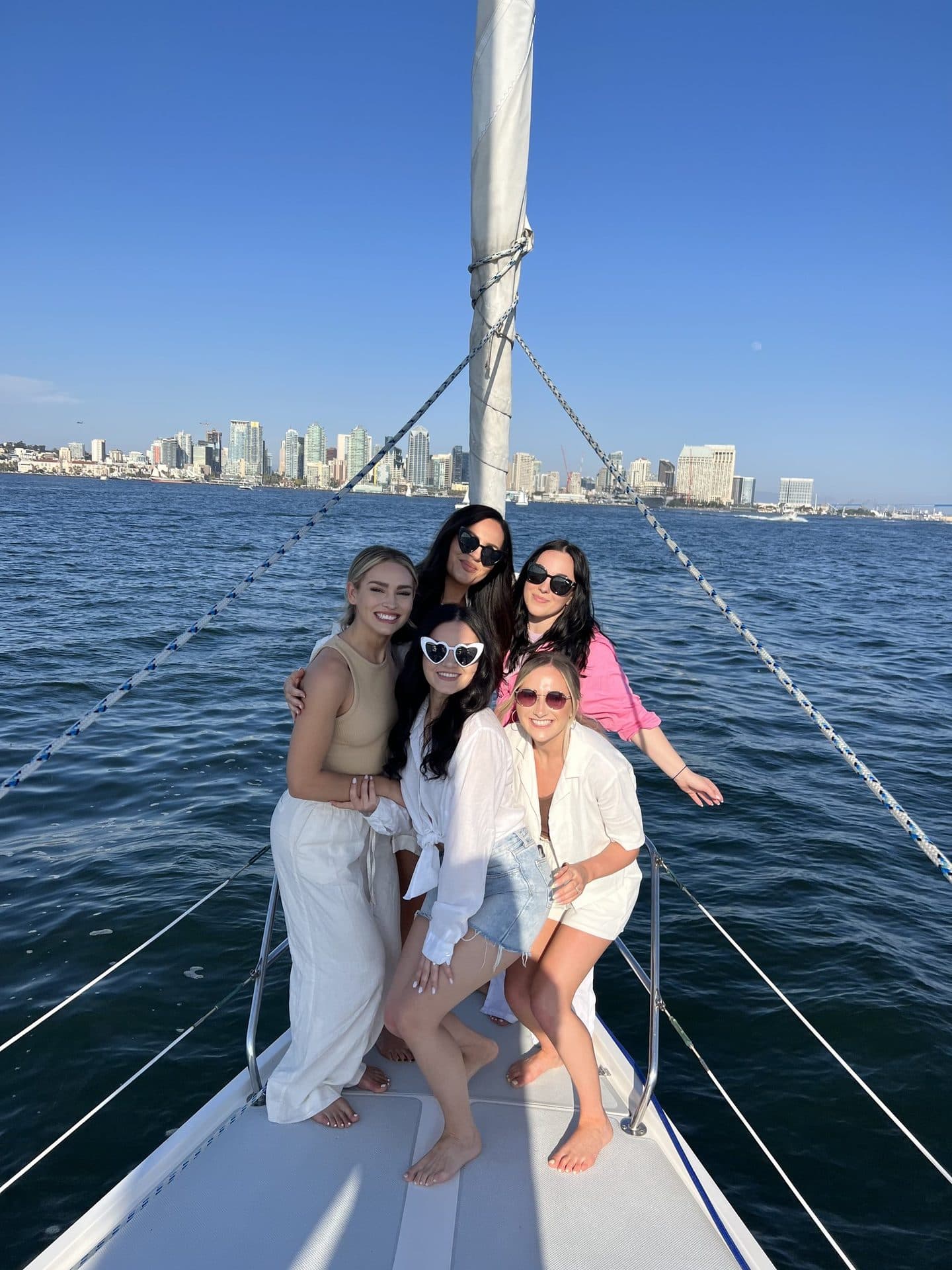 A bachelorette group celebrating on the bow of the Mojave with the San Diego skyline