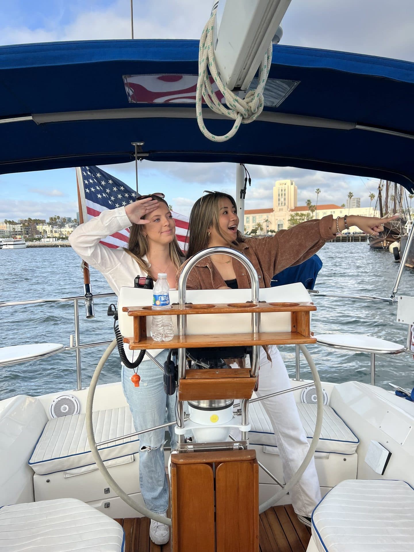 A guest at the helm with the American flag and skyline behind