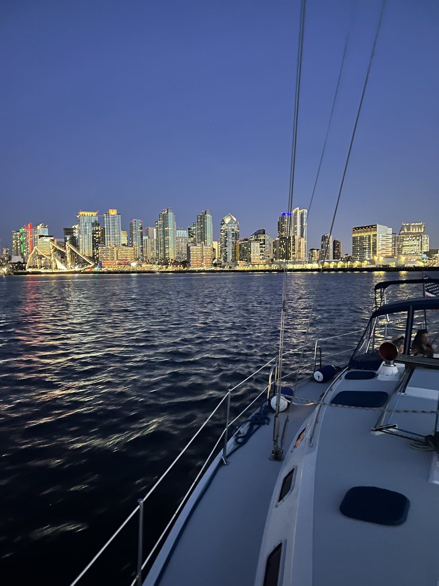The San Diego skyline lit up at dusk from the water