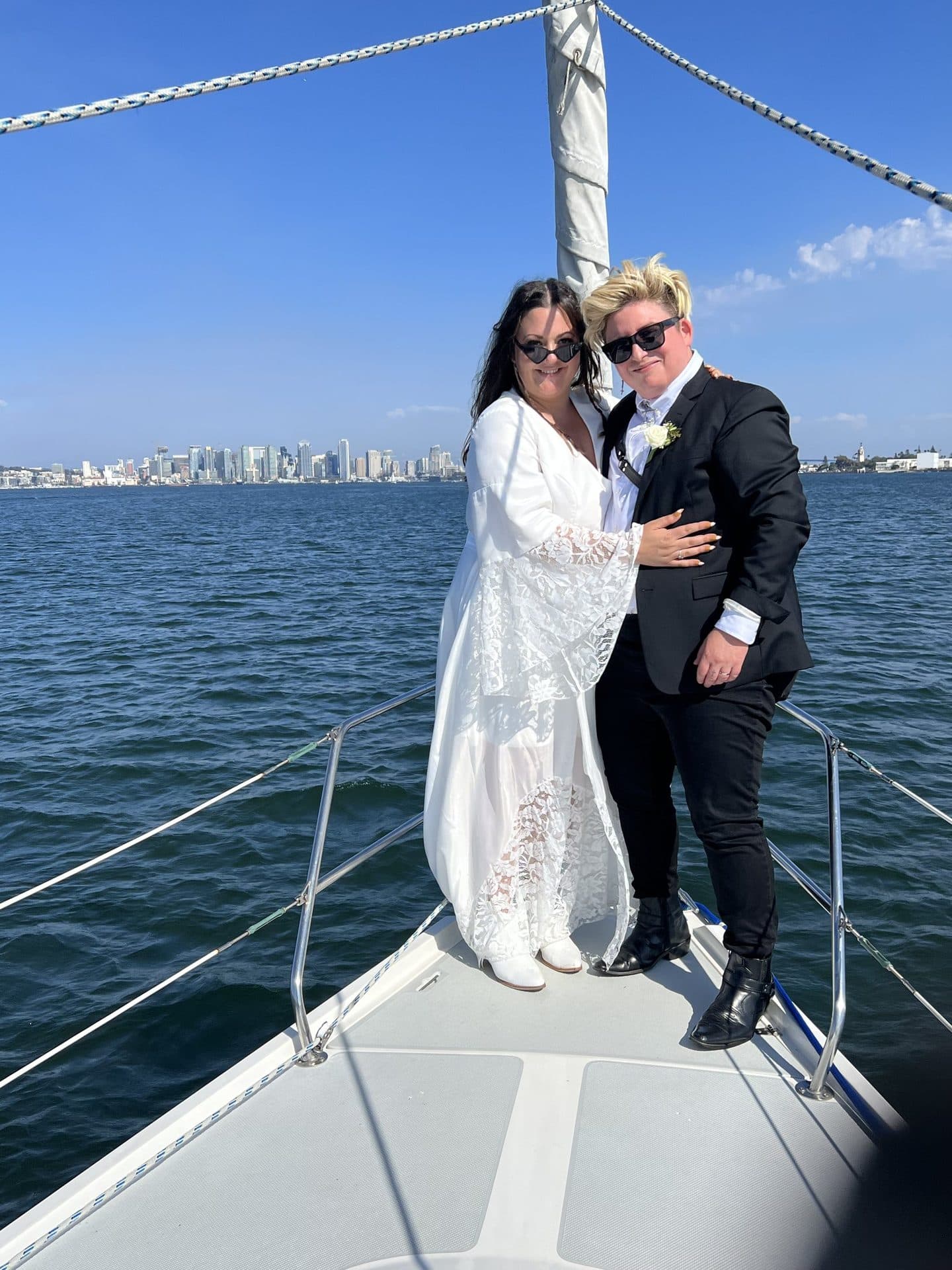 A newly engaged couple on the bow with the San Diego skyline